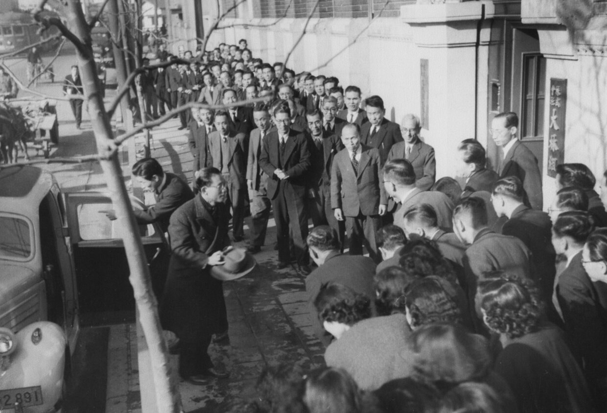 Officers and employees greeting President Yoshiro Obayashi at the entrance to the Main Office upon his return from the United States (1950)