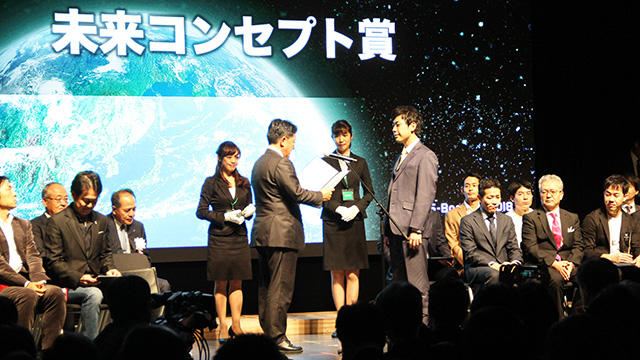 内閣府の平井卓也特命担当大臣（宇宙政策担当）（左）から表彰状を授与される大林組職員（右）。宇宙飛行士の山崎直子さんなどから有意義で世の中に大きなインパクトを与えると評価されました
