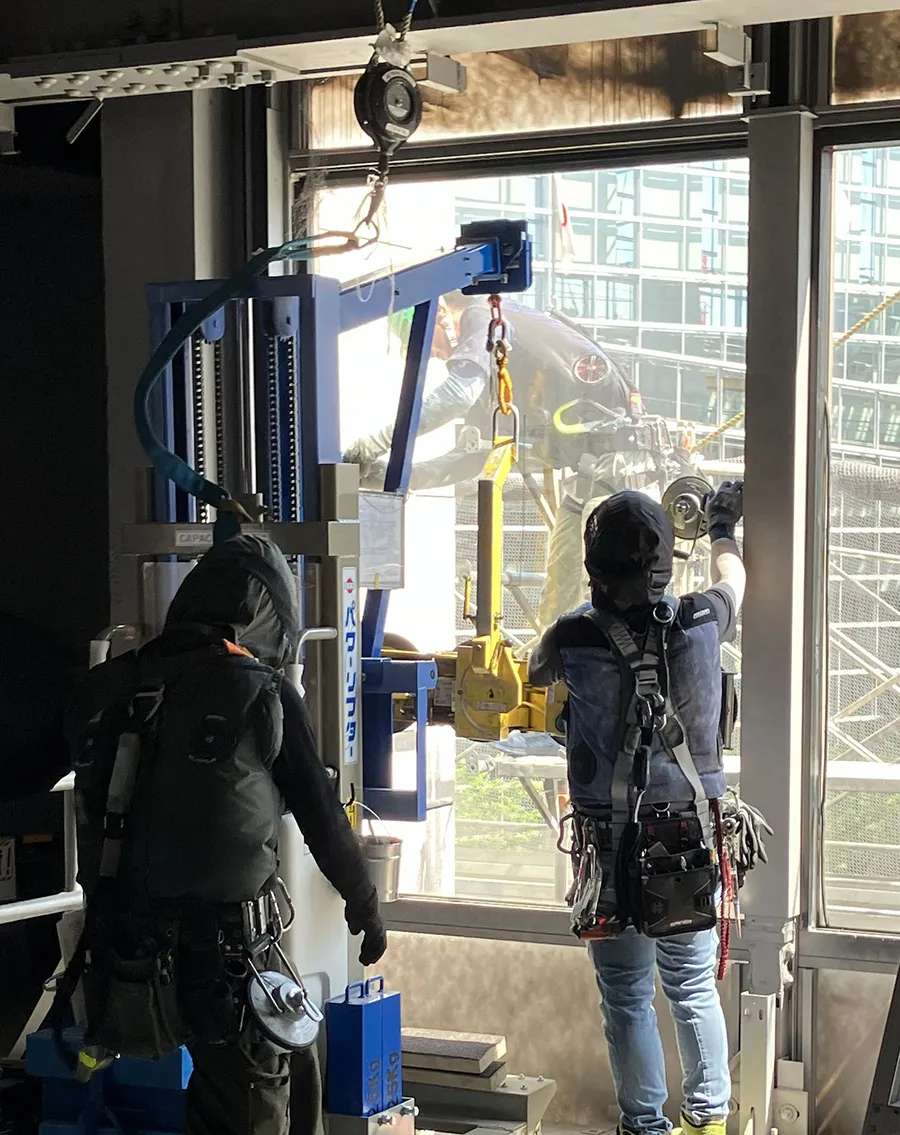 回収設備を用いて解体建物内の窓ガラスを取り外す様子