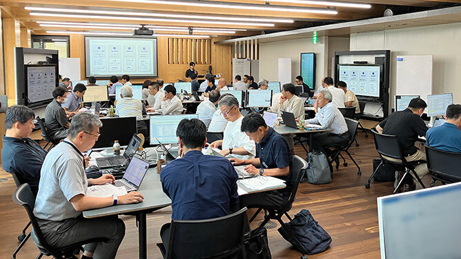 社員がチームごとに集まり、課題解決や業務改善に向けた議論や共同作業を行う研修の様子