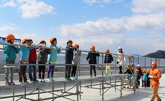 展望台に上がって橋の下に広がる景色を楽しむ児童