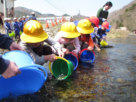 「元気に戻ってきて」と呼びかけながらそれぞれが70匹の稚魚を放流